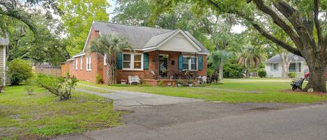 A single-story house with a front porch, a driveway, and a lawn.