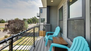 Ein Balkon mit zwei Stühlen, einem Tisch und Blick auf die Straße.