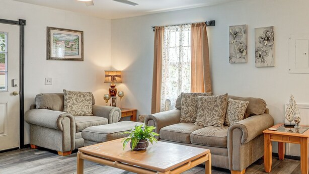 A living room with two sofas, a coffee table, a lamp, and artwork on the walls. - Panama City Fall Getaway: Pool & Near Events (Panama City)