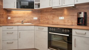 A kitchen with a built-in oven, a coffee machine, and a sink with a faucet. - In attraktiver Lage des Ostseebades Sellin (Sellin)