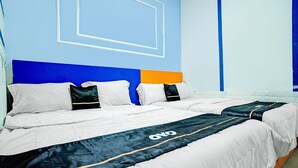 Quarto de hotel com uma cama grande, cabeceira com design geométrico e parede com padrão semelhante.
