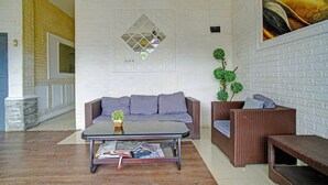 Uma área de estar moderna com um sofá, uma mesa de centro e uma poltrona de vime.
