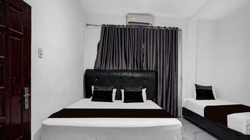 A room with a bed, a bedside table, a wardrobe, and an air conditioning unit.