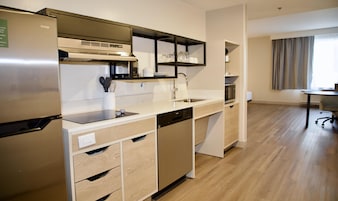 A modern kitchen with a built-in dishwasher, a stainless steel refrigerator, and a microwave.