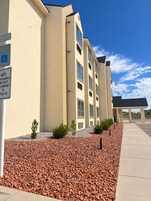 Un edificio de varios pisos con estacionamiento y cielo despejado.