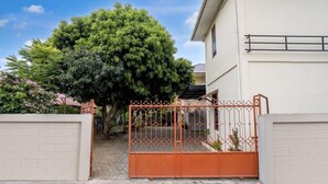 A gated entrance to a building with a large tree in the background.