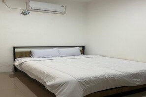 A single bed with white bedding in a room with a white wall and an air conditioning unit above it. - Deluxe Double near Cihampelas Walk (Bandung)