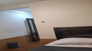 A bedroom with a bed, a door, a wall socket, and a trash bin. - Single Room near Cihampelas Walk (Bandung)