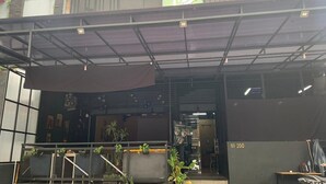 A covered outdoor area with a metal roof, a signboard, and a number 'NO 200' on a wall. - Single Room near Cihampelas Walk (Bandung)