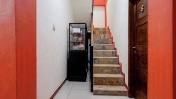 A narrow hallway with a staircase leading to a door.