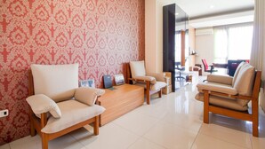 A modern living room with a patterned wallpaper, a wooden coffee table, and two sofas.