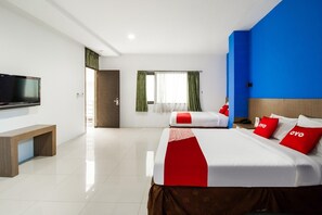 Ein Hotelzimmer mit Bett, Nachttisch, Fernseher und einem fenster mit Vorhängen.