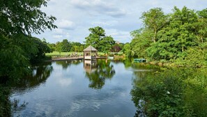 A tranquil lake with a gazebo, surrounded by lush greenery and trees. - Historic 2BDR Cottage in Dulwich Village (Greater London)