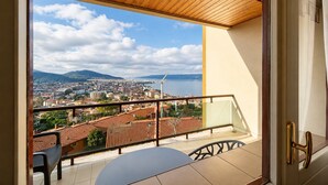 Uma varanda com vista para a cidade, uma mesa e uma cadeira.
