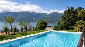 Piscina com vista para montanhas e um lago.