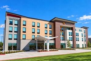 A multi-story hotel with a modern facade, featuring a mix of wood and brick materials. - La Quinta Inn and Suites by Wyndham Central McKinney (McKinney)