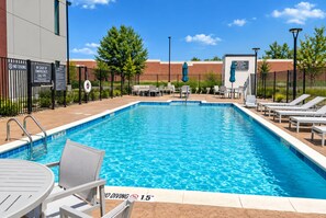 A rectangular swimming pool with a no diving sign, surrounded by lounge chairs and a brick building in the background. - La Quinta Inn and Suites by Wyndham Central McKinney (McKinney)