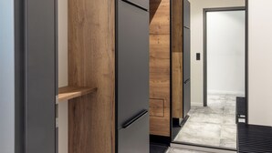 Una cocina moderna con gabinetes de madera, un refrigerador negro y una encimera gris.