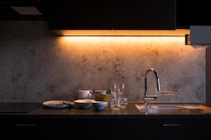 Una cocina con mostrador, lavabo y salpicadero.