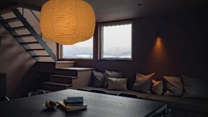 A modern interior with a wooden dining table, a staircase, and a large window with a view. - monel (Nakafurano)