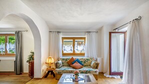 Un salon avec un canapé, une table basse et une fenêtre avec des rideaux.