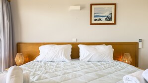 A neatly made bed with a quilted bedspread, two pillows, and two rolled towels. - #357 Sea View Getaway in Portimão | Pool & Spacious (Portimão)