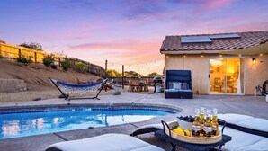 A backyard with a swimming pool, lounge chairs, a hammock, and a barbecue area. - Pool + Firepit + BBQ | Near Park + DT Yucca Valley |  The Light of the Desert (Yucca Valley)