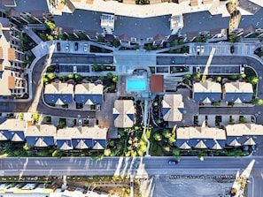 An aerial view of a residential area with a central pool, arranged houses, and a main road. - Private Hot Tub + BBQ + Communal Pool | Walk to Lifts | Blackstone Chalet (Park City)