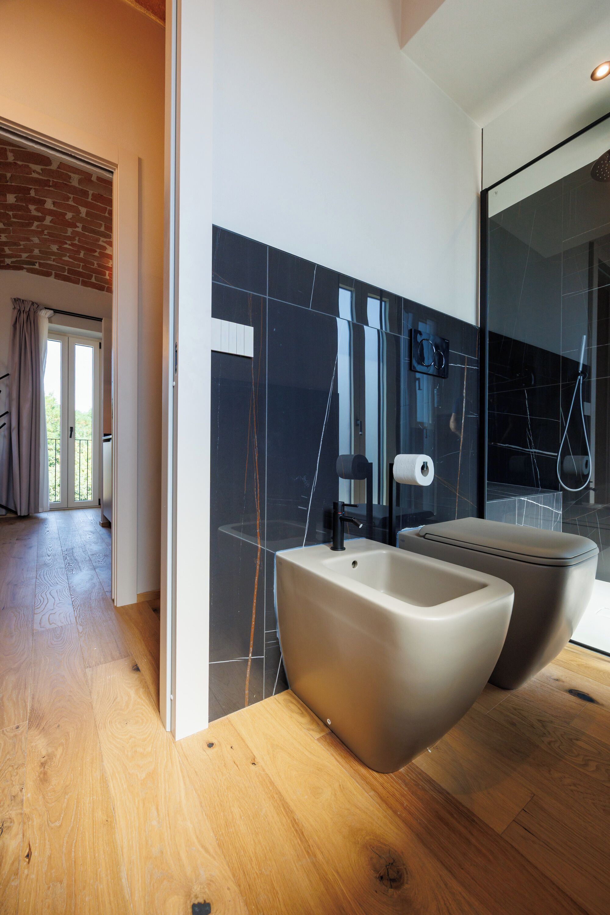 A modern bathroom with a large bathtub, a sink, and a glass shower enclosure.