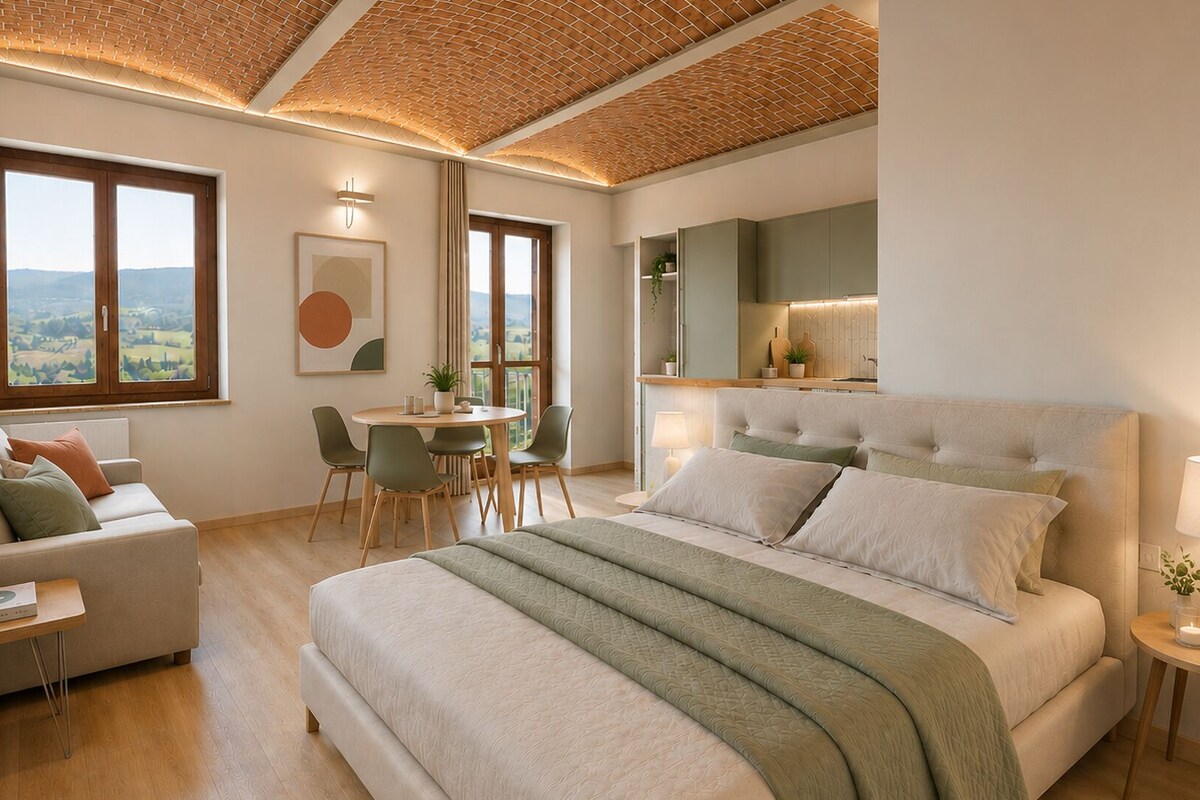 A modern bedroom with a large bed, a dining area, and a kitchen in the background.
