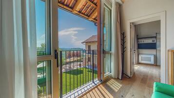 A balcony with a view of a green lawn and a building with a tiled roof.
