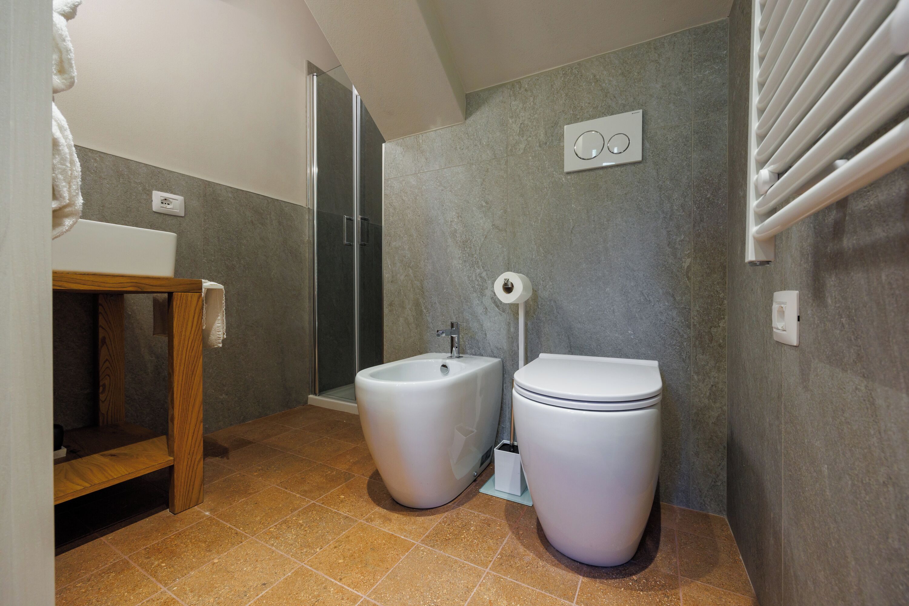 Une salle de bain équipée d’une douche, d’un bidet, de toilettes et d’un porte-serviettes.