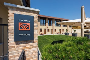 A building with a stone facade and a sign for 'Calanga Apartments.' - Calanga (Barbaresco)