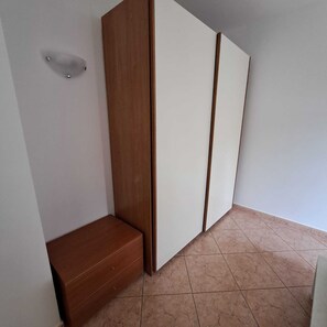 A room with a wooden bench, a white wardrobe, and a tiled floor. - Casa Zefiro – Private Entrance with Courtyard, 10 min from the Beach (Marzocca)