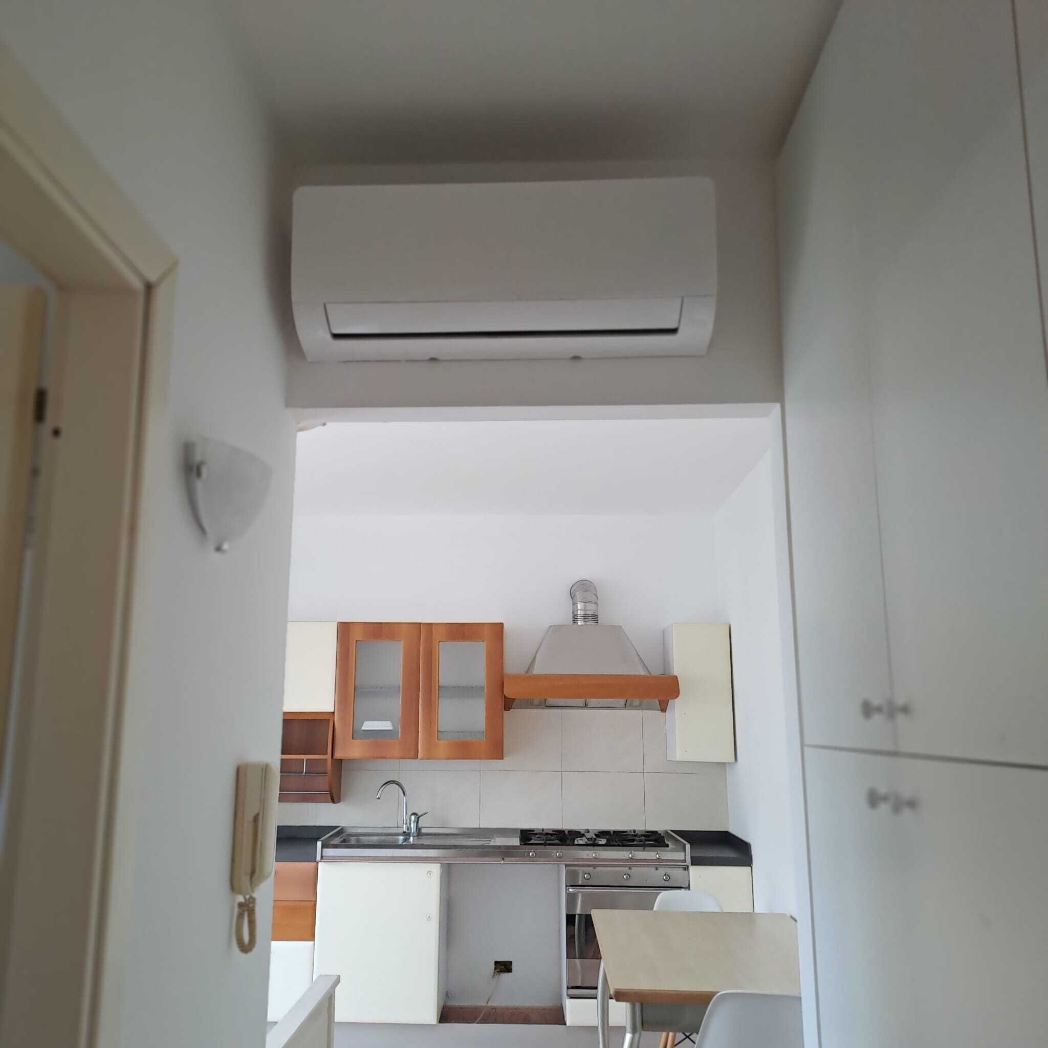 A compact kitchen with a built-in stove, a sink, and wooden cabinets.