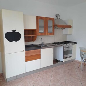 A kitchen with a stove, oven, and cabinets. - Casa Zefiro – Private Entrance with Courtyard, 10 min from the Beach (Marzocca)