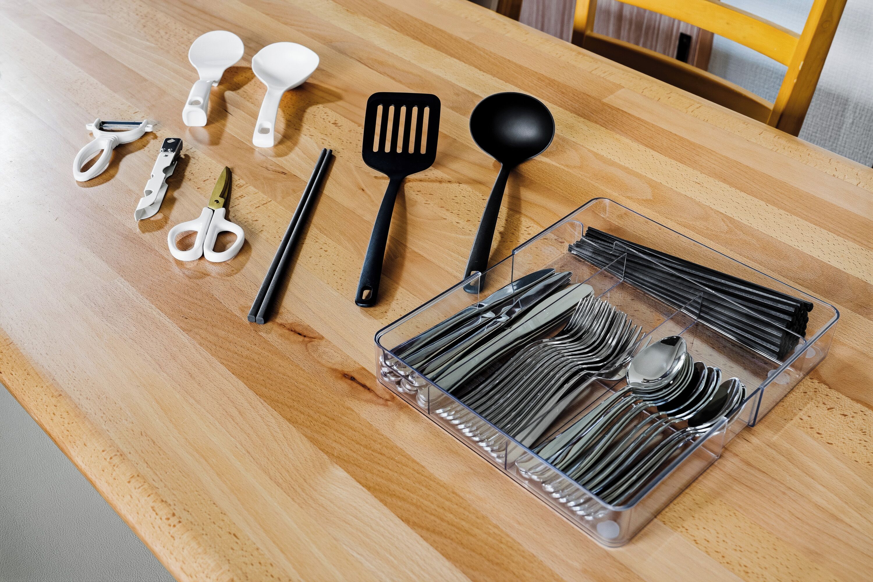 Una mesa de madera con utensilios de cocina y un organizador.