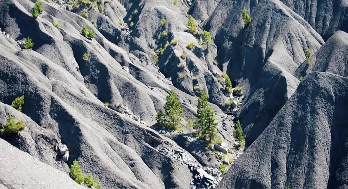 Un paysage montagneux accidenté, caractérisé par un terrain rocheux et une végétation clairsemée.