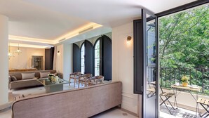 A modern living room with a sofa, chairs, a coffee table, and a balcony with outdoor furniture. - Genteel Home Casa Pilatos Terrace (Seville)