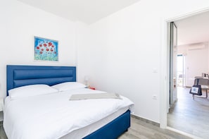 Ein Hotelzimmer mit Bett, einem Gemälde, einem Nachttisch und Blick auf den Speisesaal.