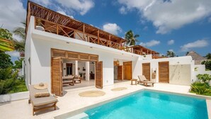 Uma villa moderna com piscina, persianas de madeira e telhado de palha.