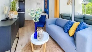 Una sala moderna con un sofá, una mesita y un jarrón decorativo.