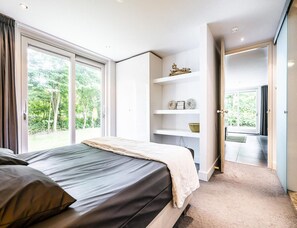 Ein Schlafzimmer mit einem Bett, einem Fenster und einer Tür, die auf einen Balkon führt.