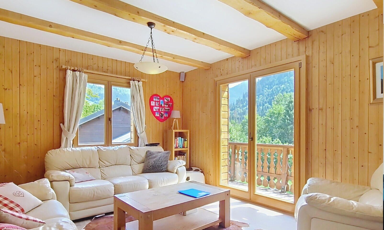 A wooden-paneled room with a sofa, a coffee table, and a bookshelf.