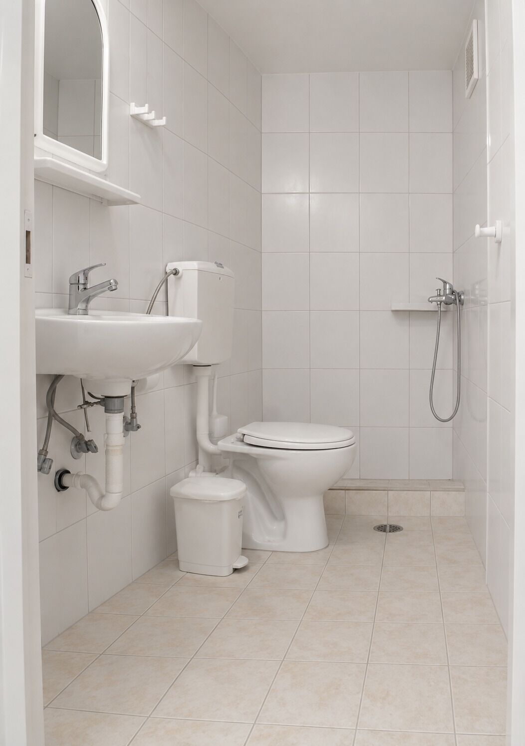A modern bathroom with a toilet, sink, and shower.