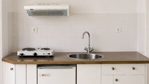 Une cuisine compacte équipée d’un lave-vaisselle intégré, d’un évier et d’une cuisinière.