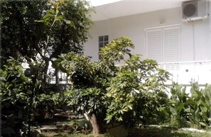 A building with a white exterior, a window, and an air conditioning unit.