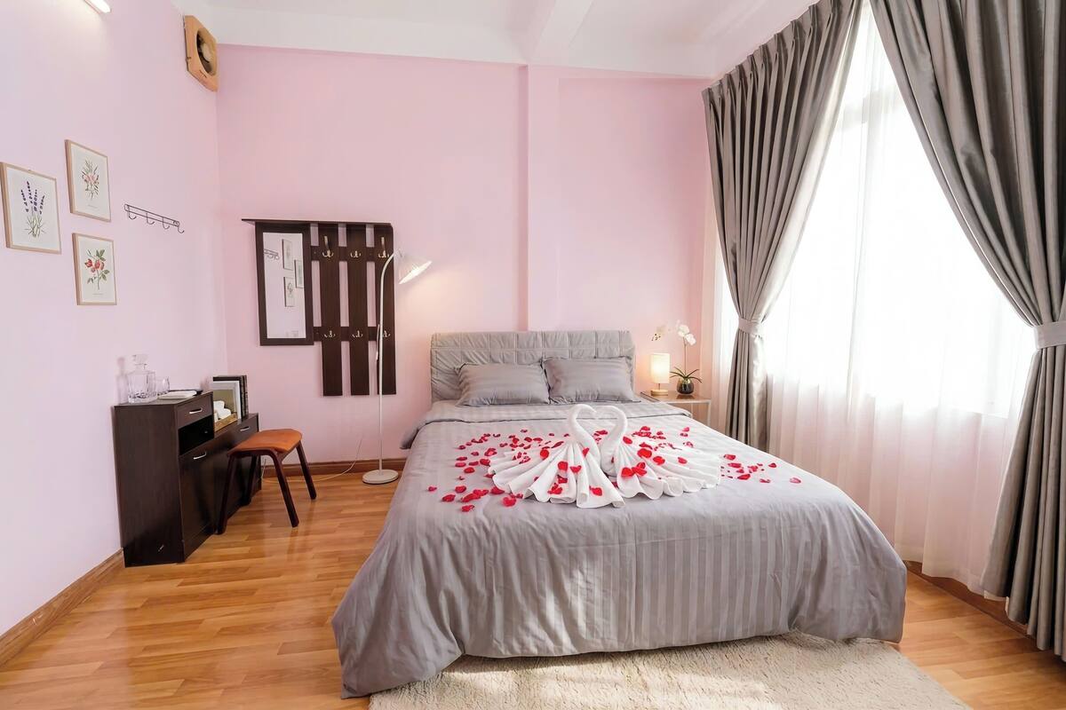 A bedroom with a bed, a desk, and a chair.