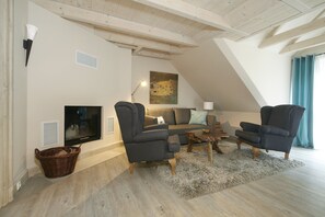 A living room with a TV, two armchairs, a sofa, a coffee table, and a painting on the wall. - Apartment fur 8 Personen mit Balkon in Uckeritz (Ueckeritz)