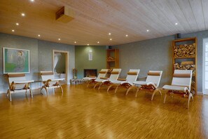 A room with wooden flooring, a fireplace, and a row of lounge chairs. - Apartment fur 8 Personen mit Balkon in Uckeritz (Ueckeritz)
